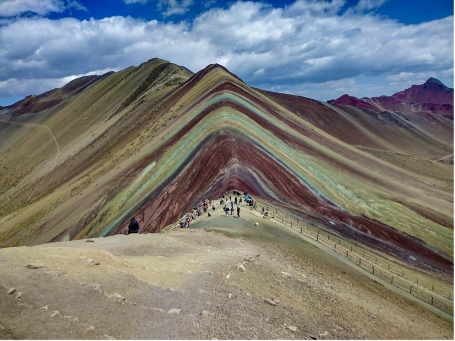 Vibrant, multi-coloured mountain ridge under a cloudy sky.