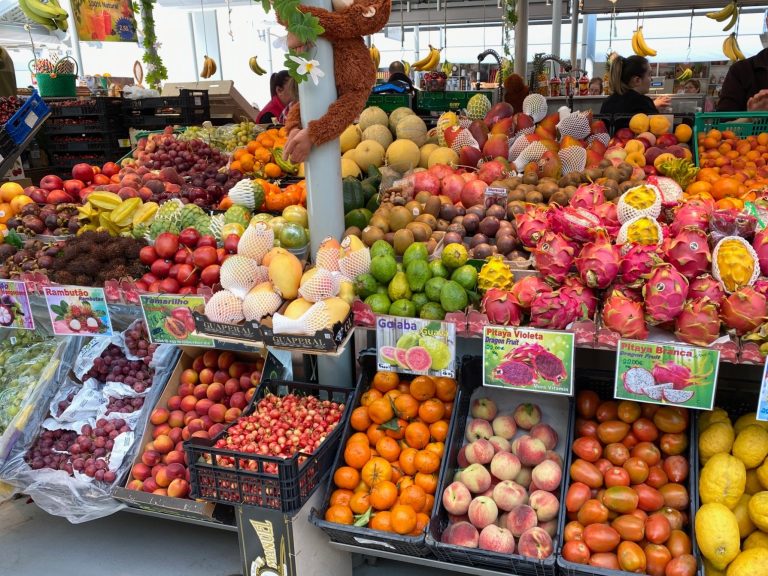 Assorted fresh fruits displayed at a vibrant market stall.
