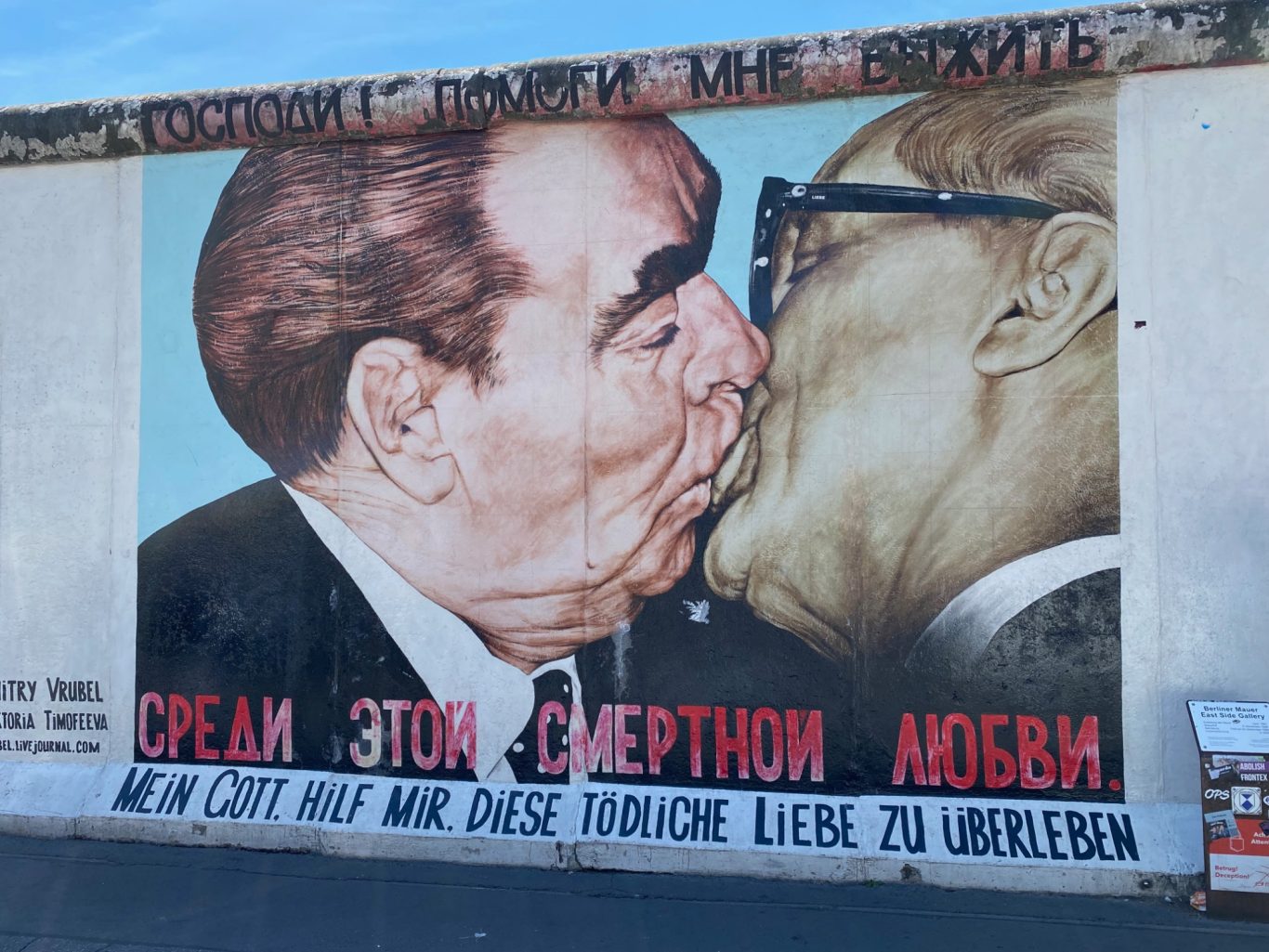 The Fraternal Kiss Mural depicting two men in a close embrace, with text in Russian about love.