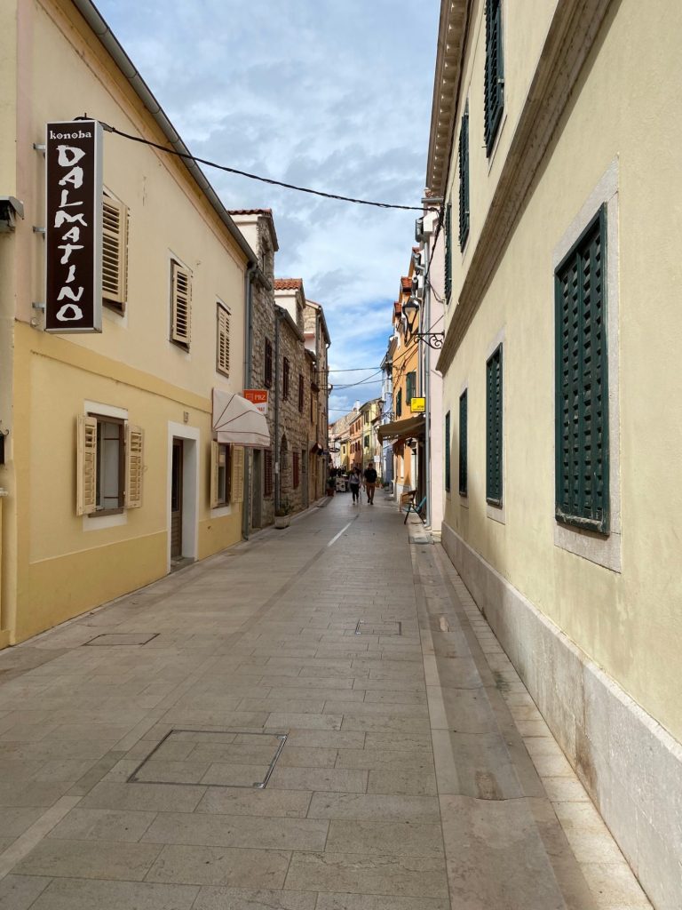 Street of the Old Town Narrow street flanked by buildings with colourful facades and shuttered windows.