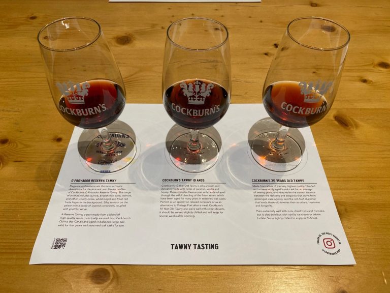 Three glasses of red wine placed on a white sheet with tasting notes underneath.