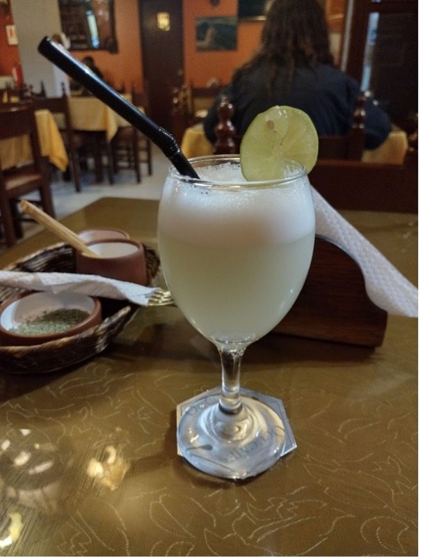 A refreshing beverage with cream and a lime slice, served in a glass.