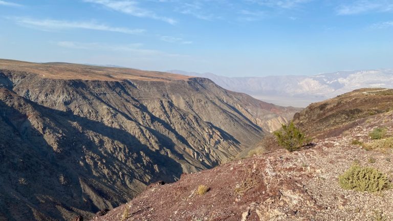 Mountainous landscape with steep cliffs and a clear sky.