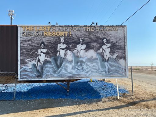 Vintage advertisement featuring three water skiers on a wave at a resort.