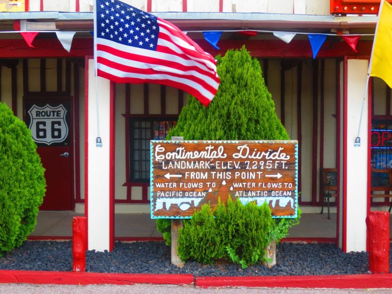 Historic diner with a Route 66 sign, American flag, and decorative foliage.