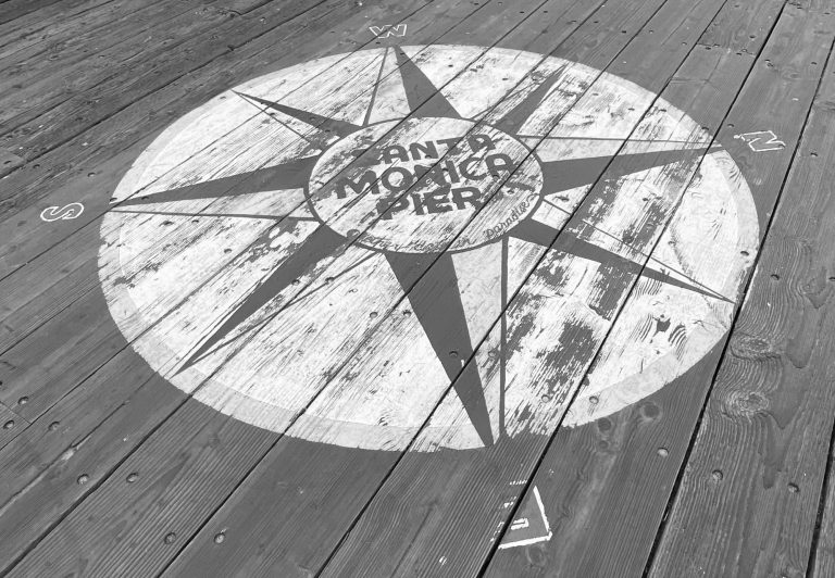 Weathered compass rose design on wooden decking.