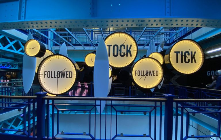 Illuminated circular signs displaying the words "TICK" and "TOCK" in a blue setting.