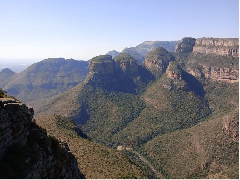 Expansive mountain landscape featuring steep cliffs and lush green valleys.