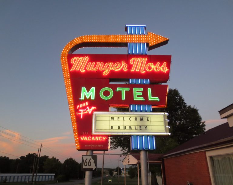 Neon sign for Munger Moss Motel with vintage design and an arrow pointing to the entrance.