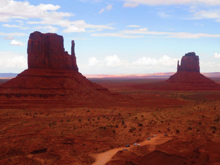 Red rock formations under a clear blue sky in a desert landscape.