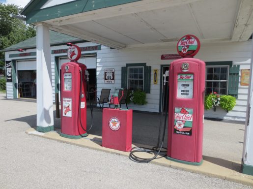 Vintage petrol station with two red pumps and a central canopy.