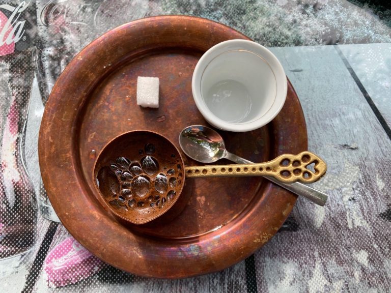 Bosnian Coffee Copper plate with a small bowl of beans, a spoon, a cup, and a sugar cube.