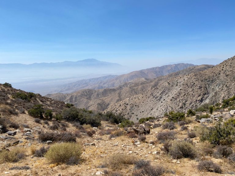 A panoramic view of a rugged mountain landscape under a clear blue sky.