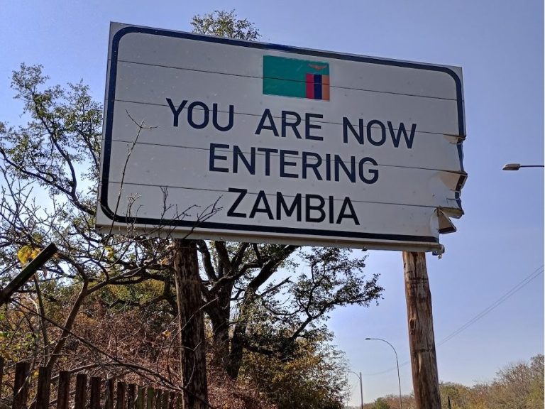 Sign indicating the entry point to Zambia, with a flag illustration.