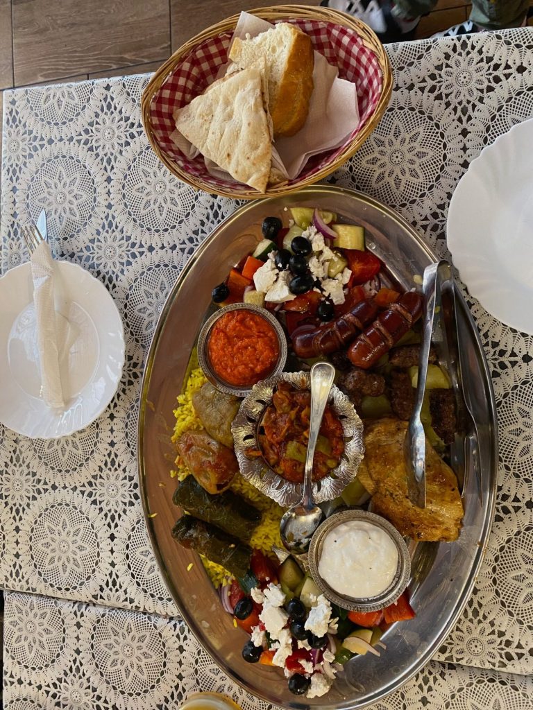 Sultan's Wedding Feast Platter A large platter of assorted foods including meats, salad, dips, and bread rolls.