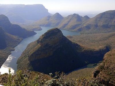 Scenic view of a winding river surrounded by mountains and lush valleys.
