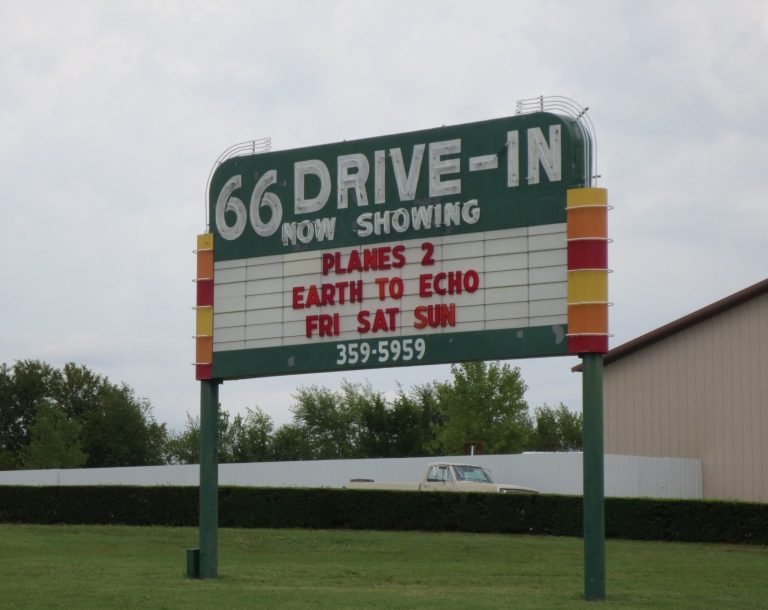 Sign for 66 Drive-In displaying movie titles for the weekend.