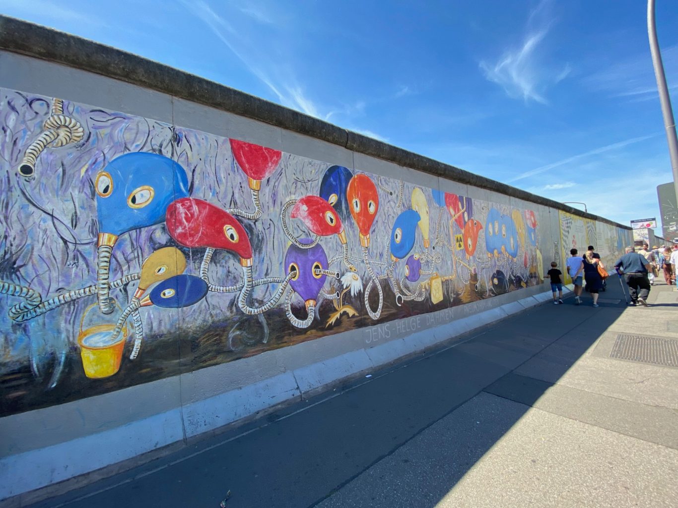 Pneumohumanoiden (Pneumo-humanoids) Colourful mural depicting quirky abstract creatures and vibrant flowers on a wall.