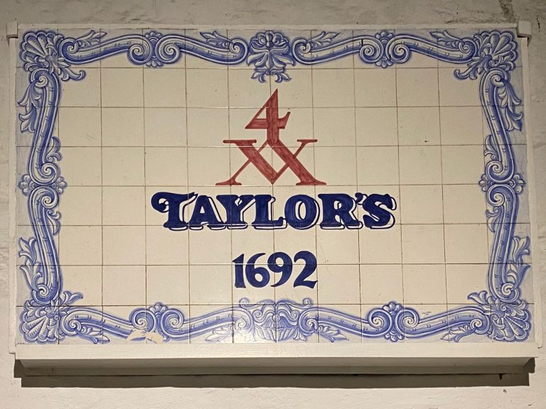 Sign featuring "Taylor's" in blue with decorative borders and "1692" at the bottom.