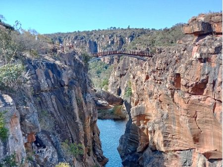 A winding river flows through a rocky canyon under a clear blue sky.